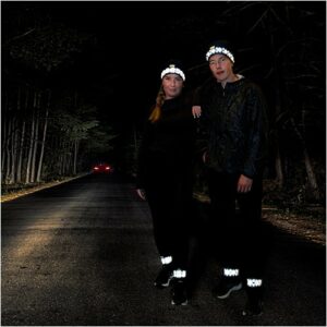 En jente og en gutt som er ute og løper i mørket. De har på seg treningsluer med refleks fra Smart in the Dark.