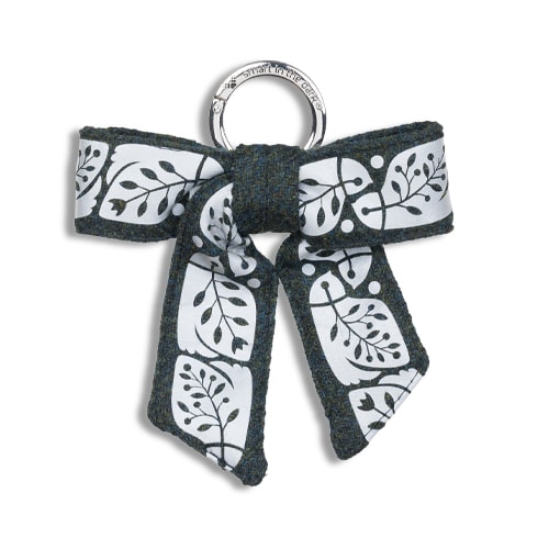 Vackert smycke till väskan i form av en reflexrosett. I färgen skogsgrön med reflexmönster av nattskärra.