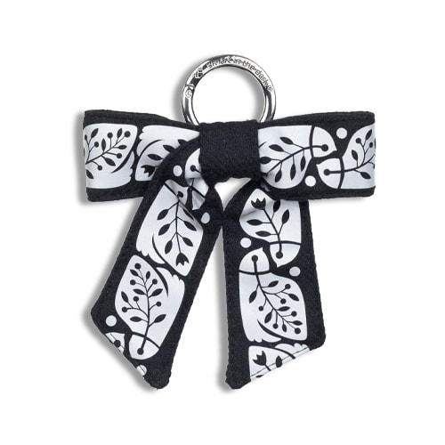 Smart reflex till väskan i form av en rosett. I färgen svart med reflexmönster av nattskärra