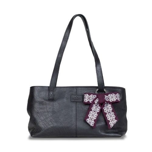 Väska med ett vackert smycke i form av en reflexrosett. I färgen plommon med reflexmönster av fyrklöver.