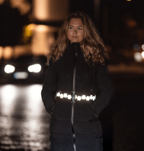 Woman with reflective belt from Smart in the dark out at night in traffic