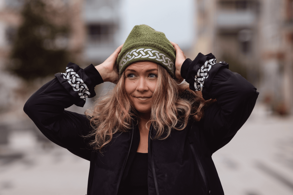 Woman with reflective clothing in the form of a warm reflective beanie hat and wrinkled reflective arm bands from Smart in the dark
