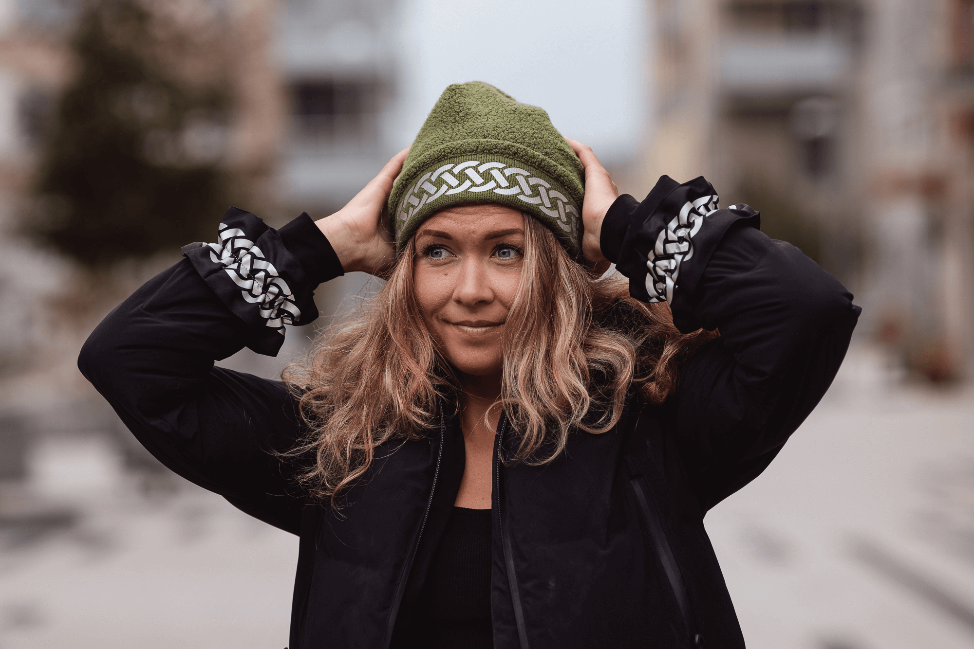 Woman with reflective clothing in the form of a warm reflective beanie hat and wrinkled reflective arm bands from Smart in the dark