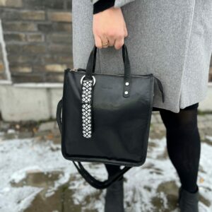 Our stylish black ELNA bag charm with reflective material for visibility in the dark. Design: Forest glade, Smart in the dark